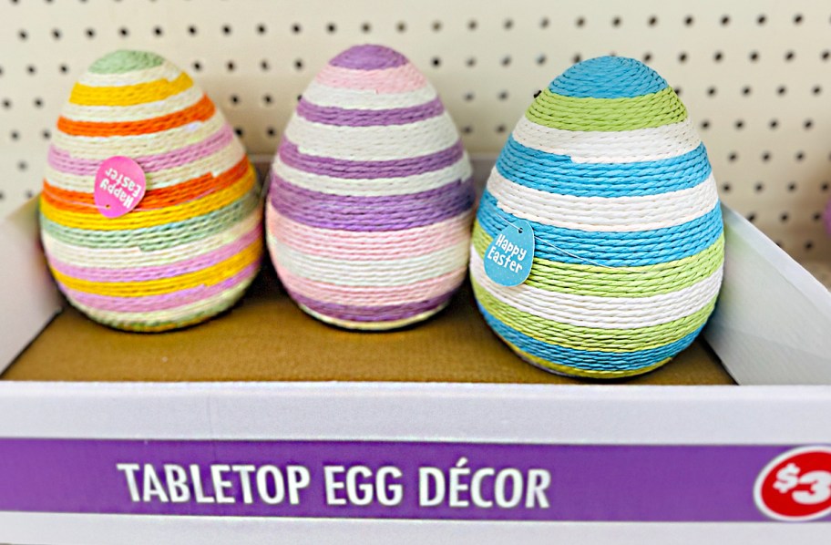three colorful eggs in box on shelf 