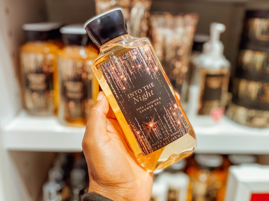 hand holding bath & body works into the night body wash