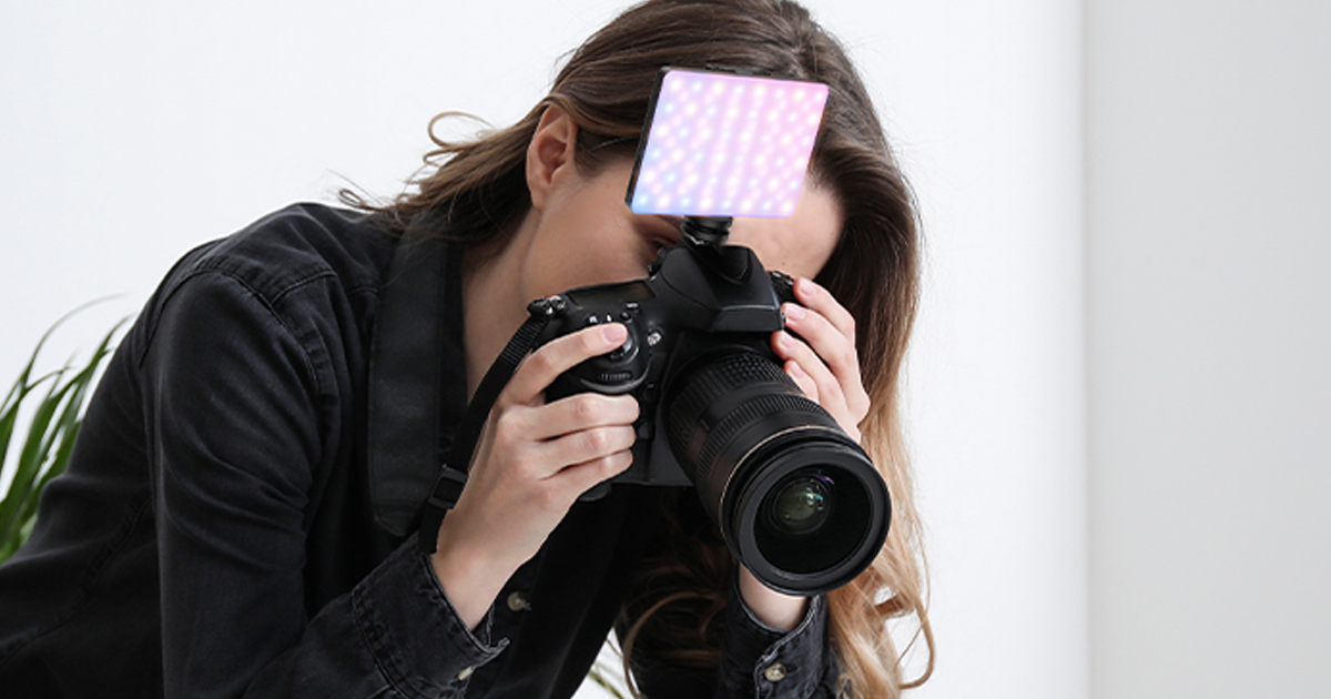 woman taking photo with selfie light attached to camera