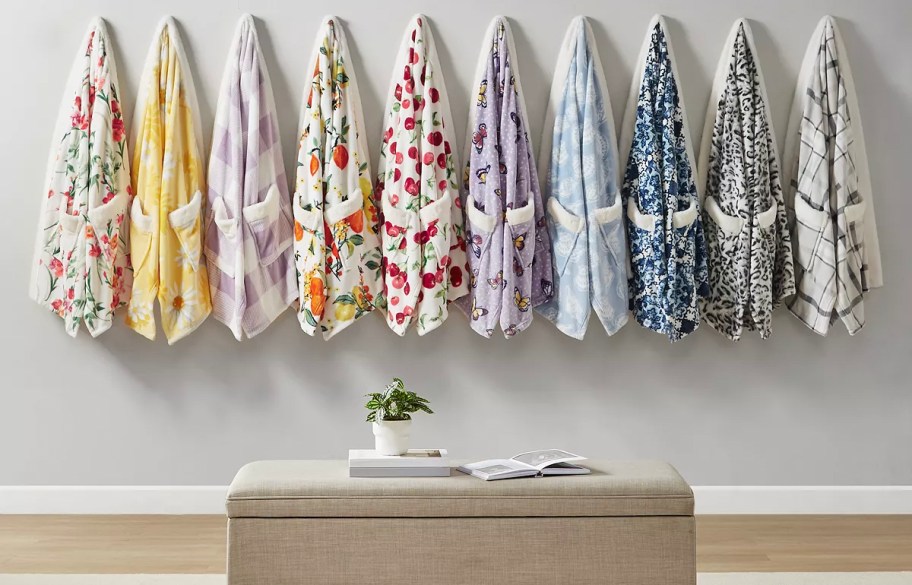 multiple cozy plush wraps hanging on wall 