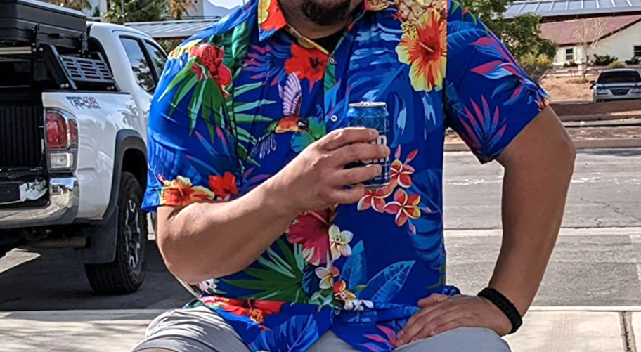 man wearing a Hawaiian style button down shirt, sitting outside