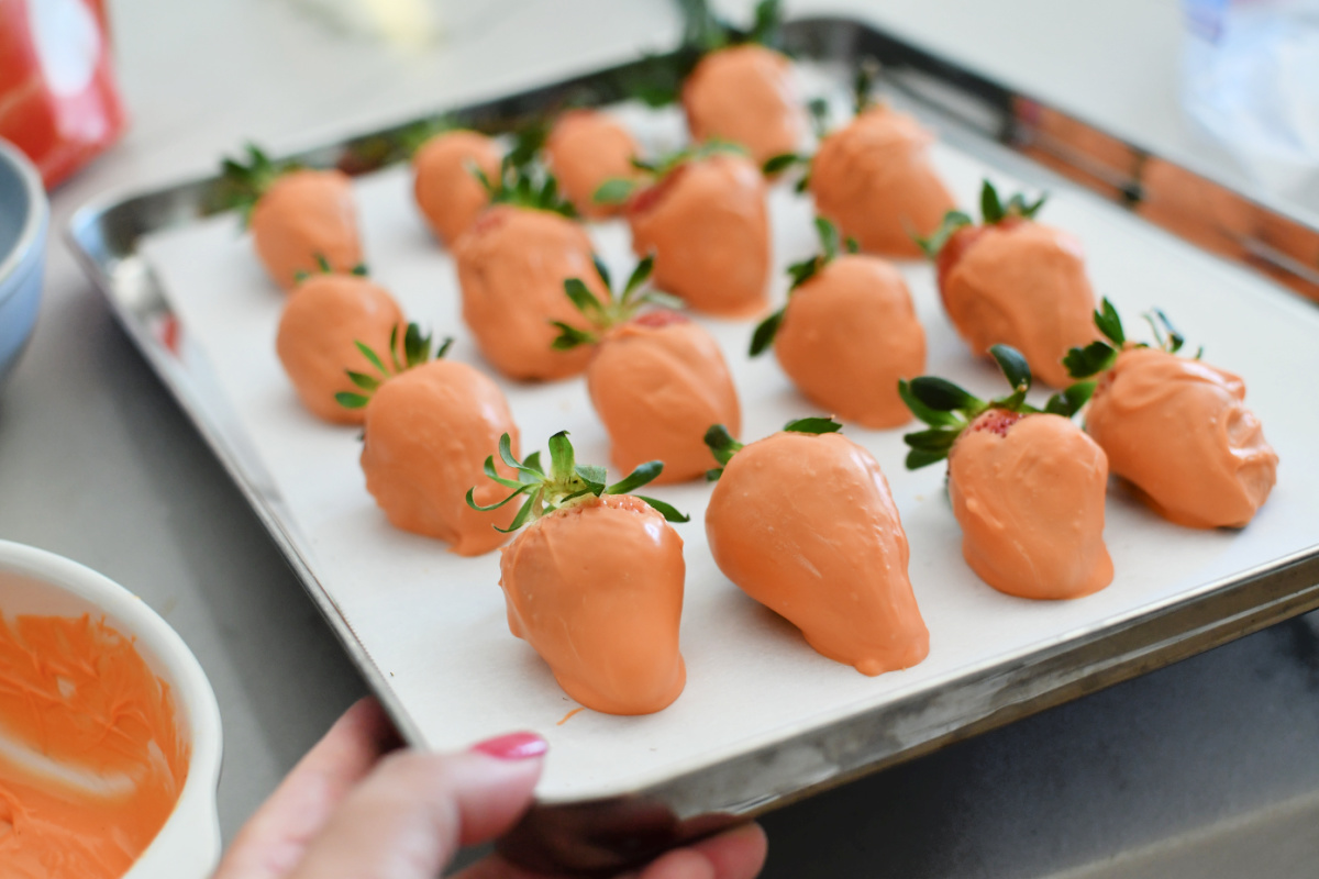 sheet pan with parchment paper and dipped strawberries