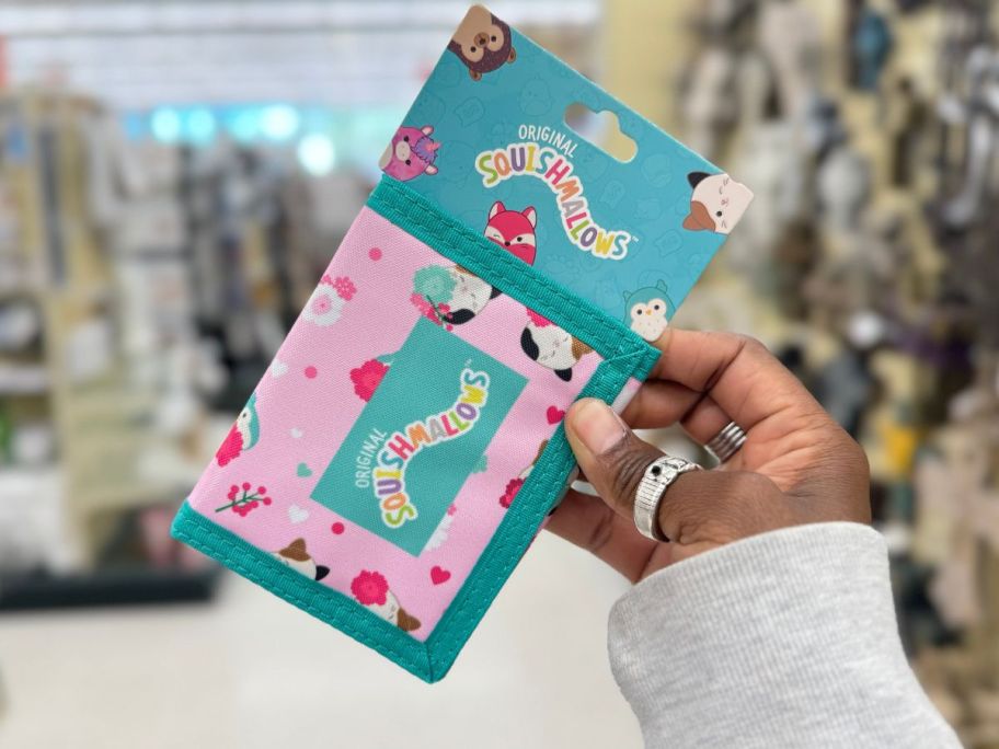 hand holding a pink and blue Squishmallows wallet