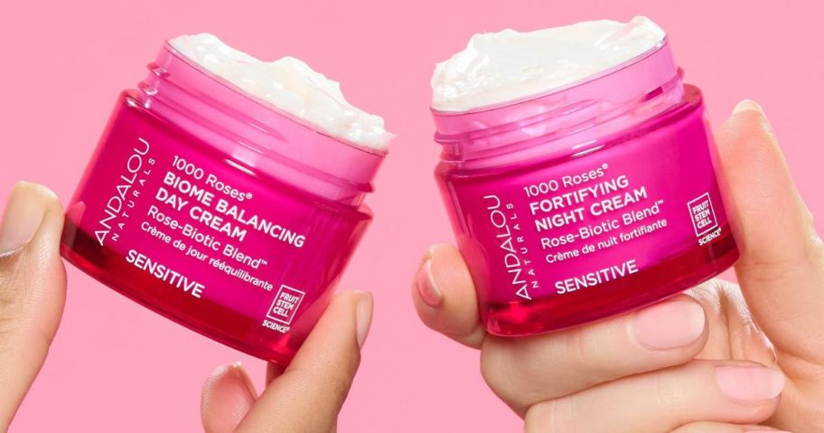 2 hands holding 2 Andalou Naturals 1000 ROSES Fortifying Night Cream jars