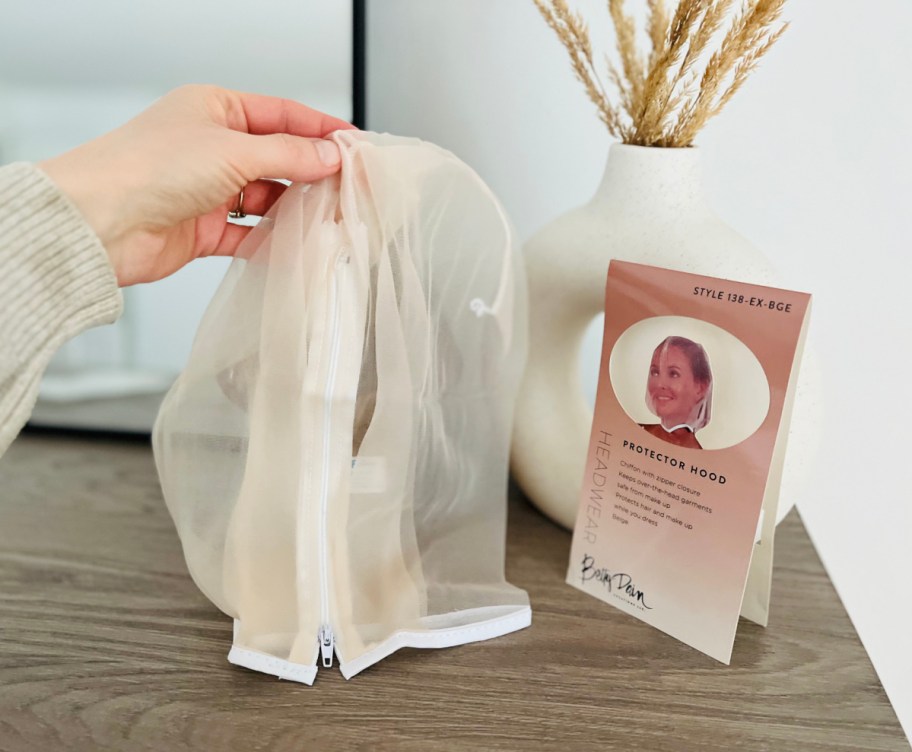hand holding up the Betty Dain Makeup Protector next to package