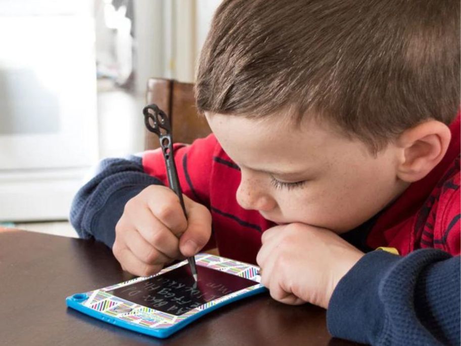 Little boy writing on a Boogie Board Tablet