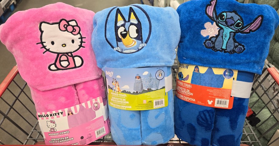 Three Character Hooded Towels with Hello Kitty, Bluey, and Stitch sitting in a shopping cart in Costco