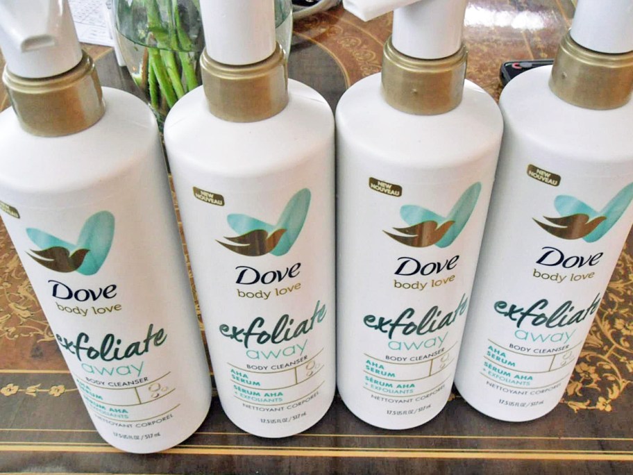 four white bottles of Dove Body Love Exfoliate Away Cleansers