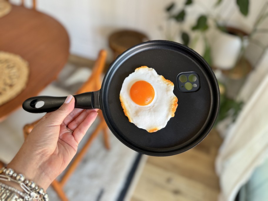 Hand holding up a frying pan phone case, one of the best white elephant gift ideas