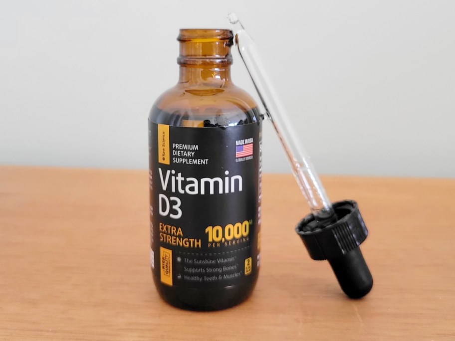 brown glass bottle with dropper leaned on the side with Raw Science Vitamin D3 on the label
