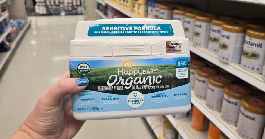 A woman holding a Happy Baby Organic Infant Formula canister