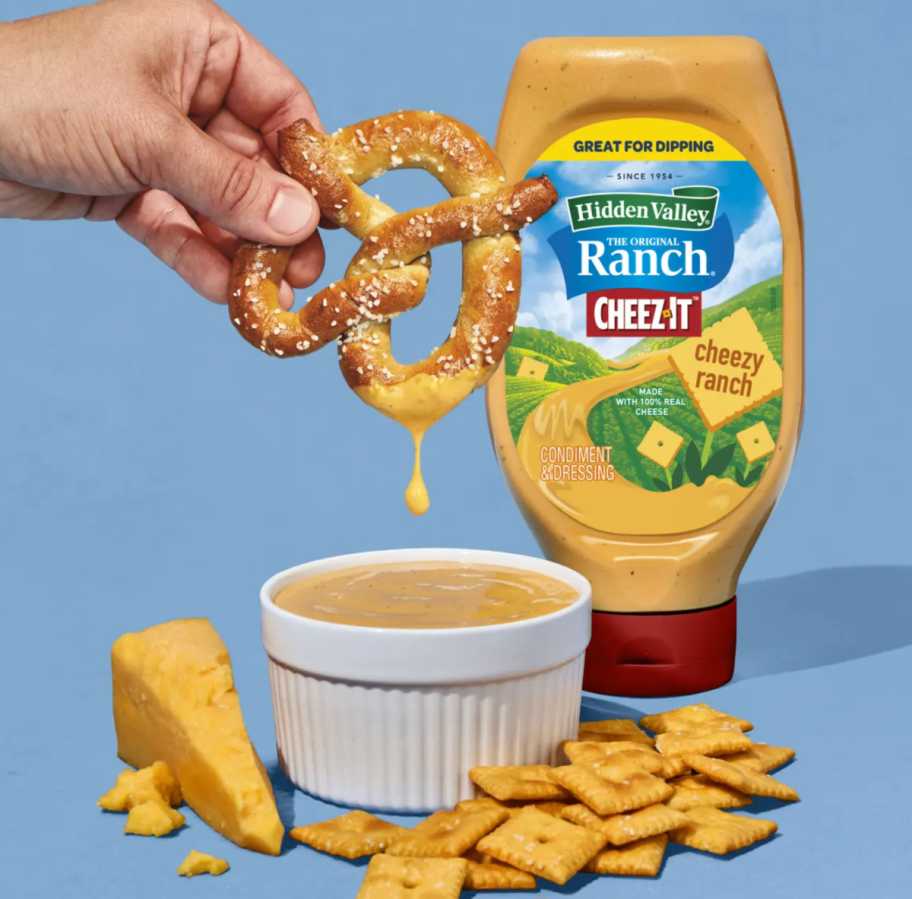 Hand dunking a pretzel in Hidden Valley Ranch Cheezy Ranch Dressing