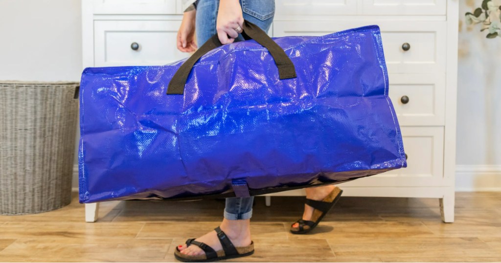 woman carrying large blue moving bag