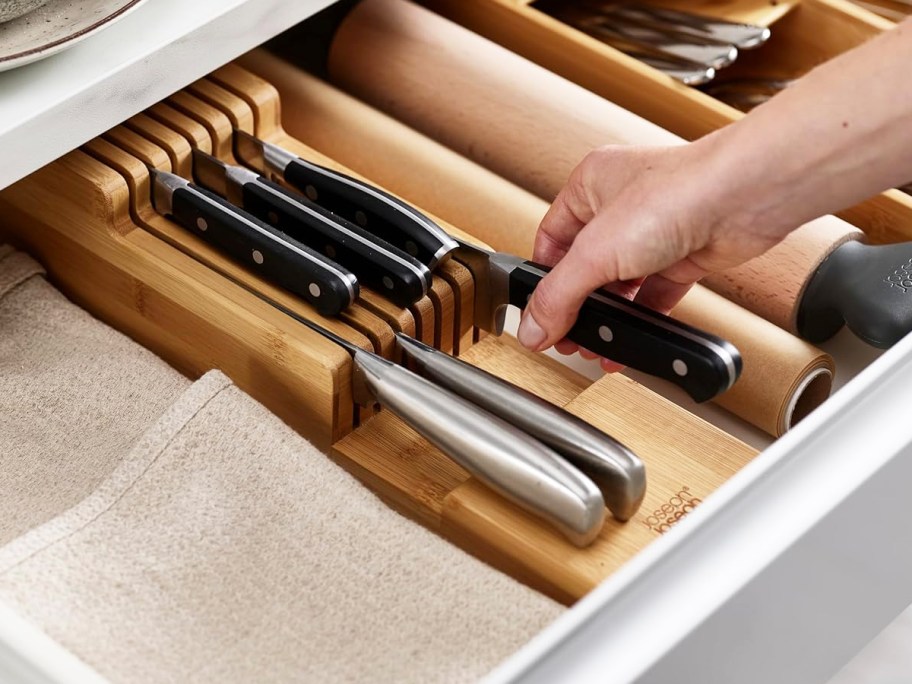 hand grabbing knife from bamboo organizer inside drawer