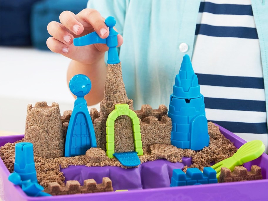 kid building a sand castle with kinetic sand