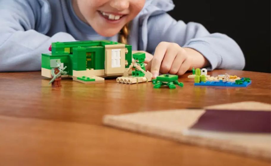 a little girl playing with a lego set on a tabletop