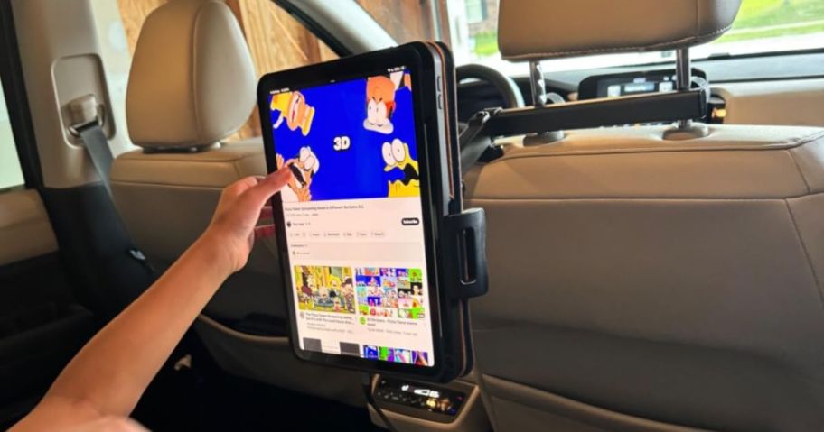 Child's arm touching a tablet on a Lisen Tablet Mount for Car Headrest
