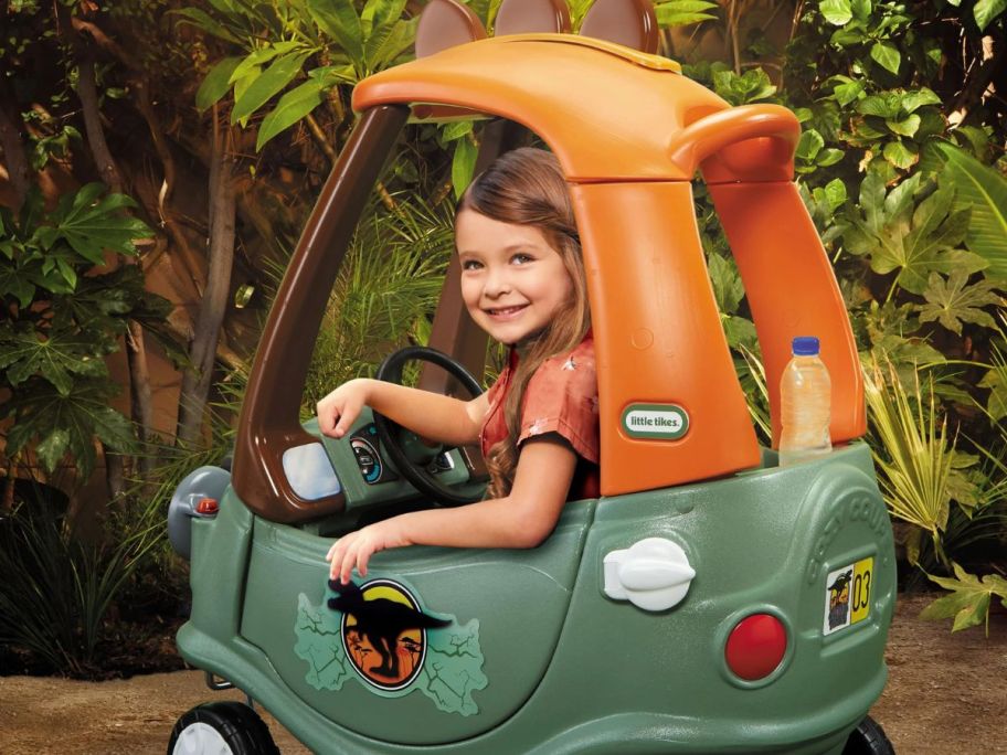 View from the back of a little girl riding in a Little Tikes Dino Cozy Coupe