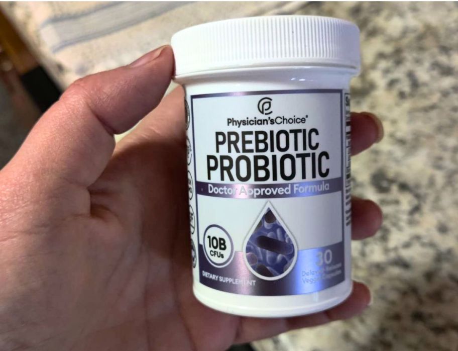 a mans hand holding a bottle of physicians choice prebiotic/probiotic