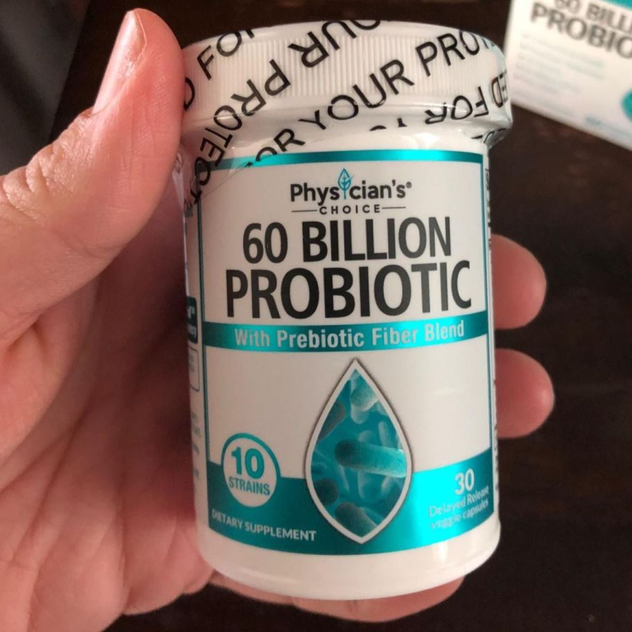 a woman hand holding a bottle of probiotics