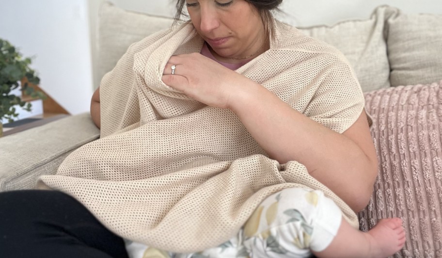 woman using a Quince Nursing Shaw while feeding her baby