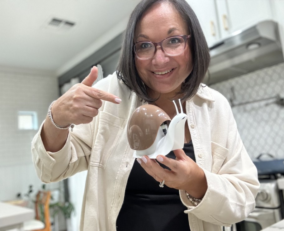 Woman holding up a snail soap dispenser