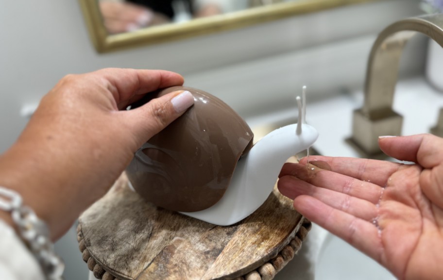 person using a snail soap dispenser