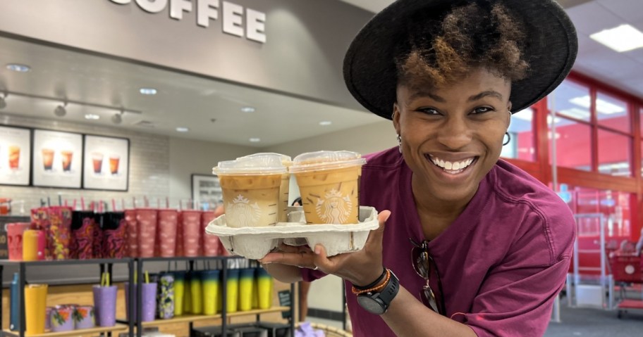 woman holding drink carrier full of starbucks drinks