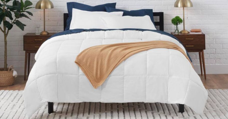 A bedroom with a white bedspread