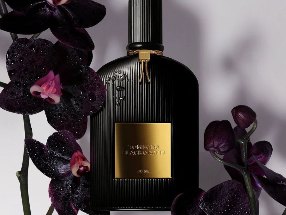 a bottle of Tom Ford Black Orchid with black orchids around it
