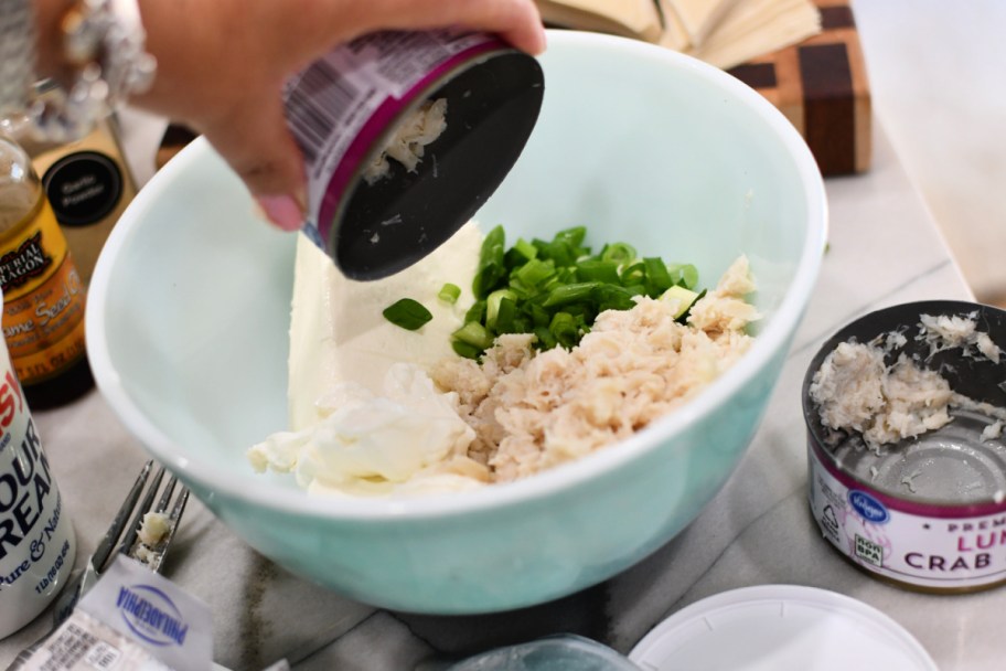 adding canned crab to a bowl with cream cheese