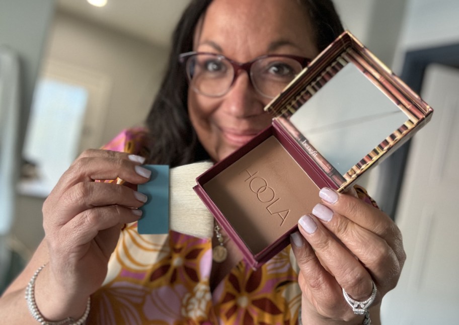 woman holding bronzer and brush