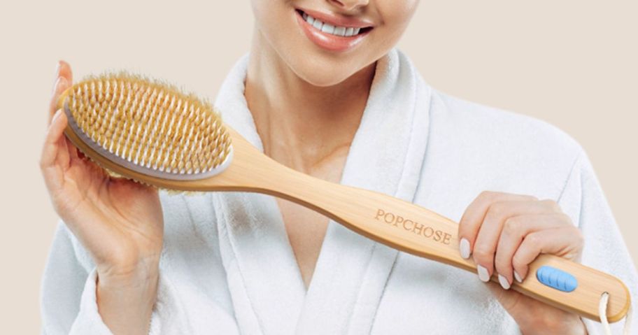 a woman holding a bamboo dry body brush