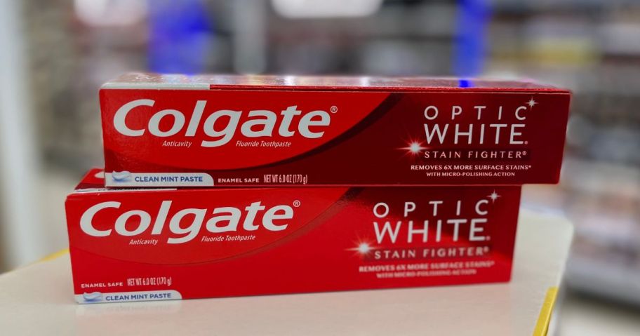 two tubes of colgate optic white on a store counter