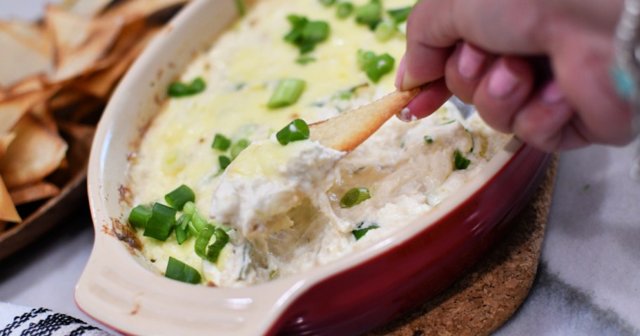 dipping a wonton into crab rangoon dip