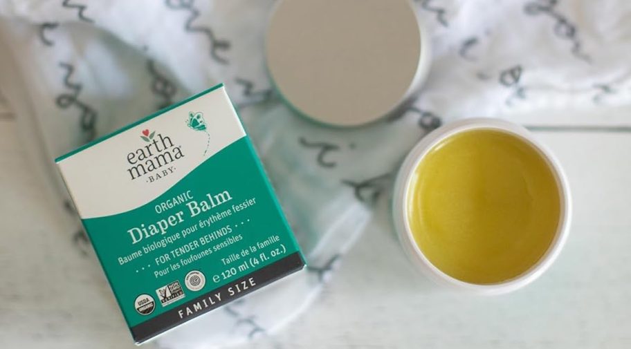 earth mama organic diaper balm and box on baby blanket