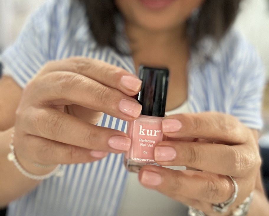 woman holding nail polish bottle