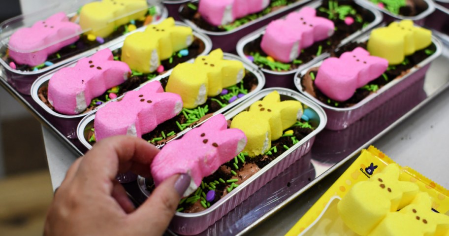 placing a peeps marshmallow on oreo dirt cake in mini pans
