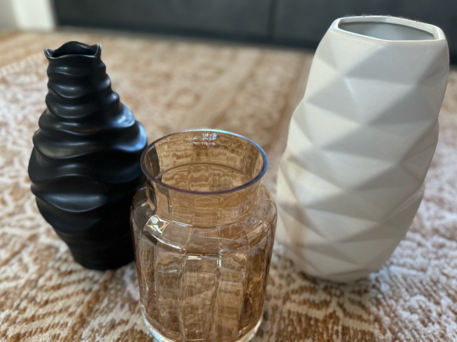 three vases on tan tablecloth