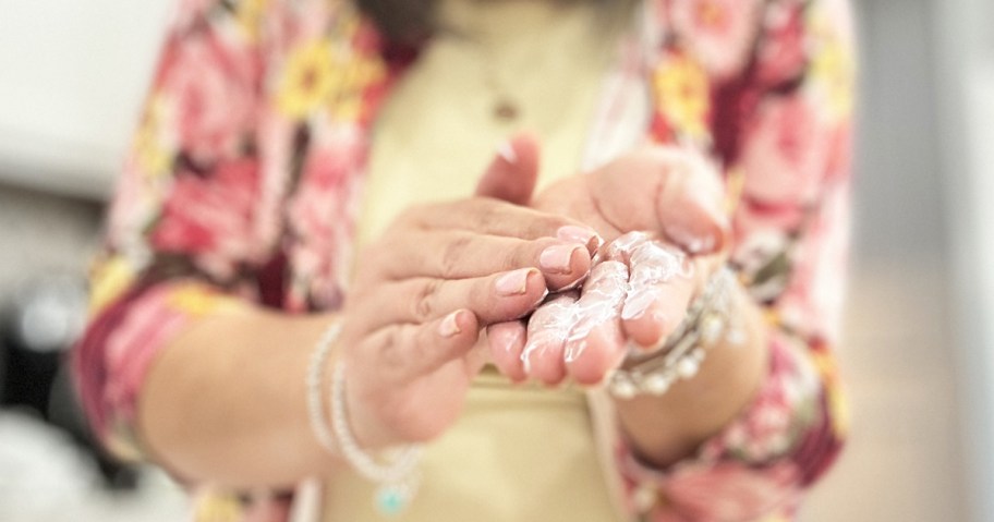 woman rubbing lotion into her hands