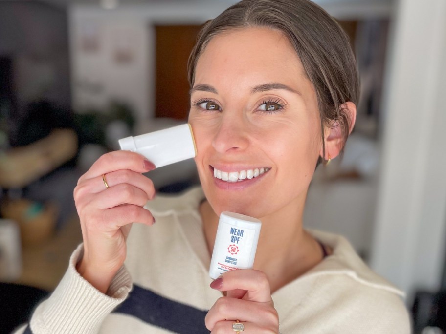 Emily applying a WearSPF sunscreen stick to her face