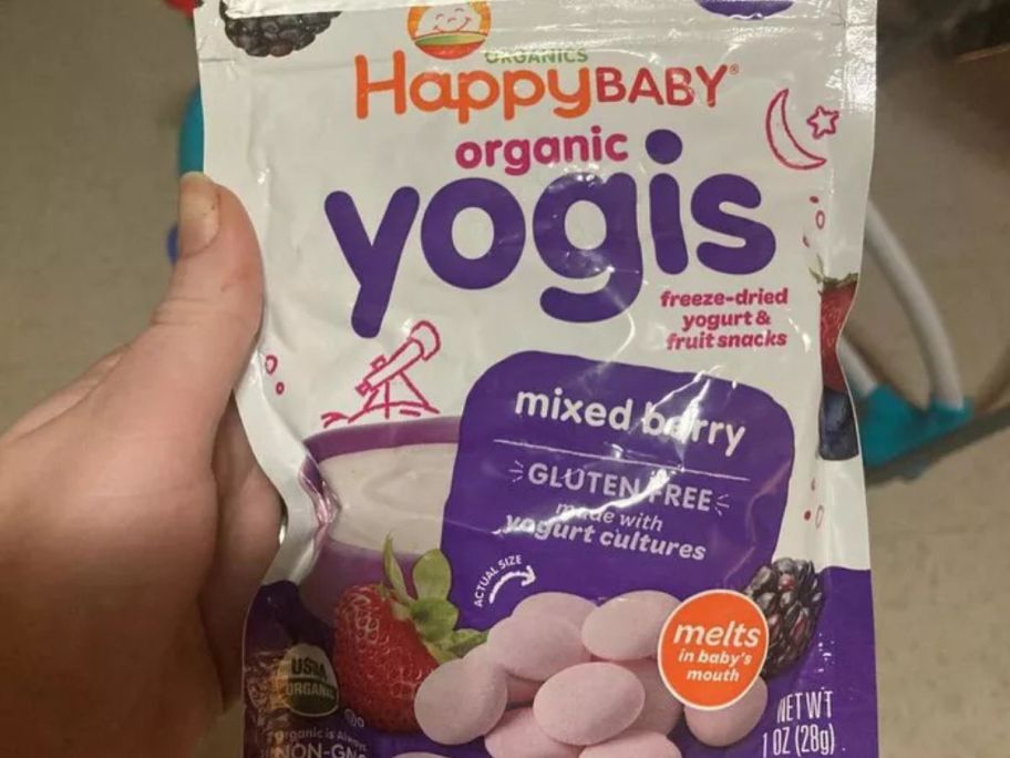 A person holding a bag of Happy Baby Organics Yogis