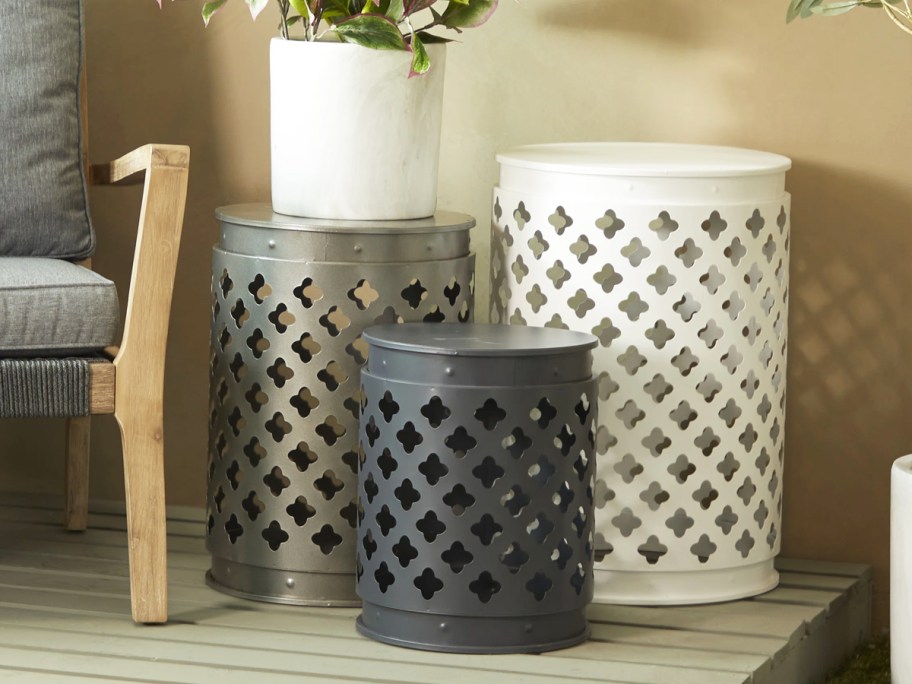 white, bronze, and black metal patio tables with cut-out designs