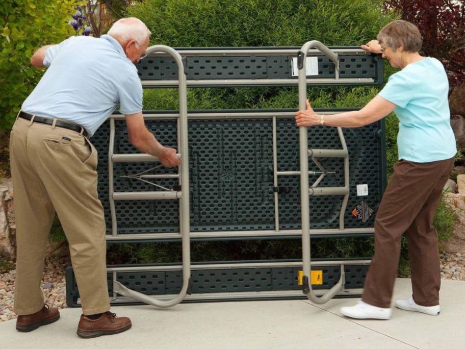 Older couple setting up a Lifetime folding picnic table