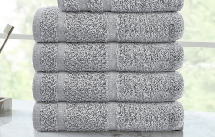 Stack of gray bath towels on counter top
