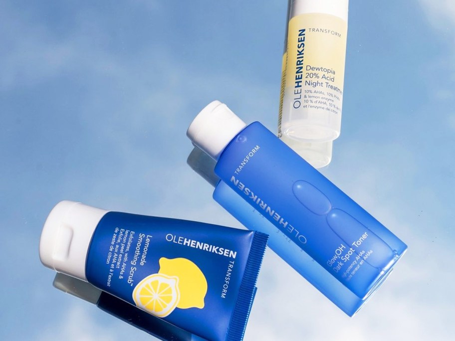 three blue and yellow OLEHENRIKSEN skincare products on blue background