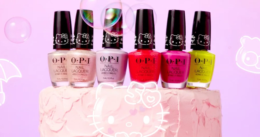 6 bottles of OPI nail polish on top of a pink cake with hello kitty