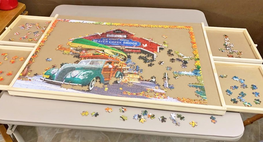 assembling a truck puzzle on a wood puzzle table with drawers