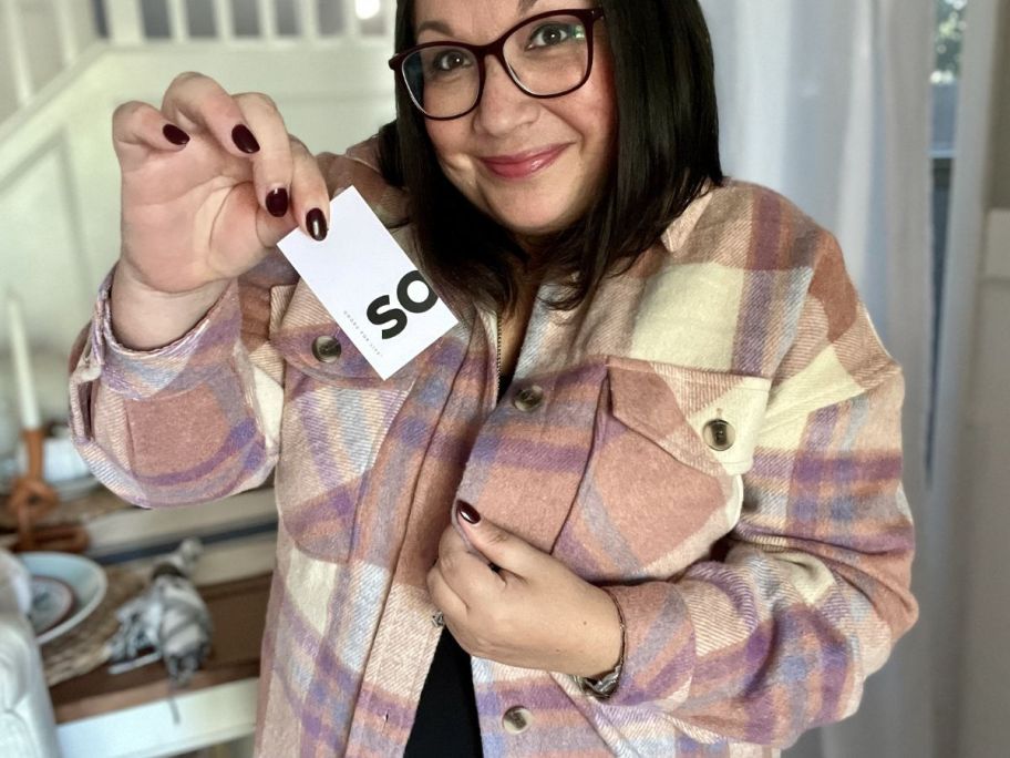 Woman wearing a SO shacket showing the tag