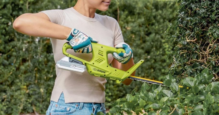 woman using a Sun Joe hedge trimmer